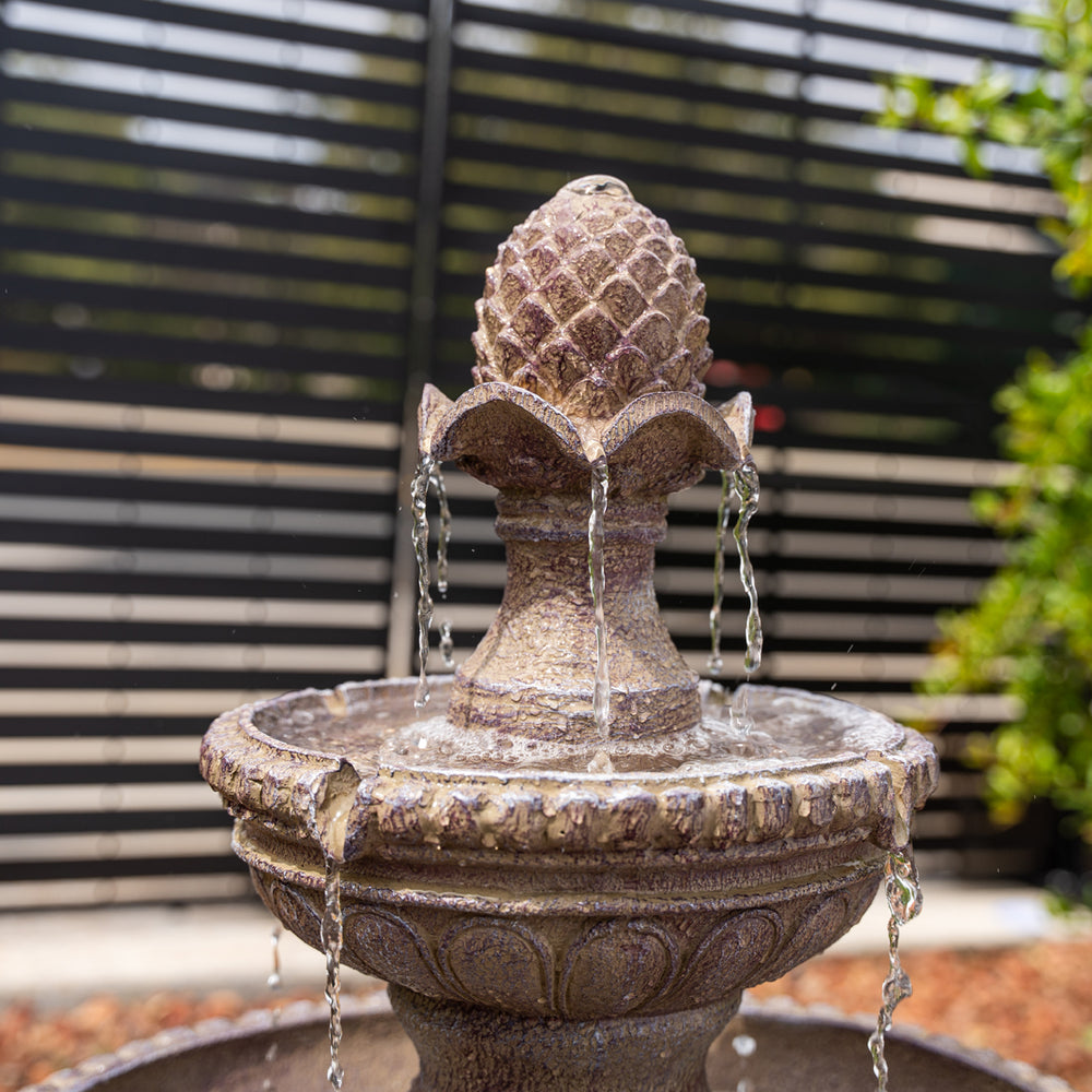 Desert Bloom — 39" Sandstone Solar Water Fountain, shown on a stone patio