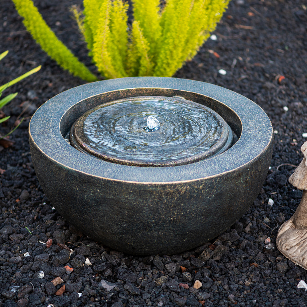Luna Bowl — 19.8" Round LED Sphere Water Fountain, black, in a landscaped garden setting